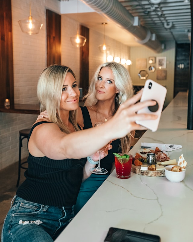 Two friends taking a selfie at a restaurant