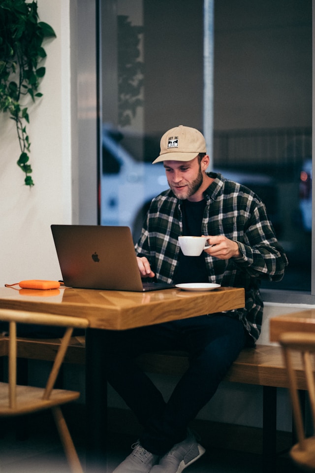 Man working on laptop in a cafe