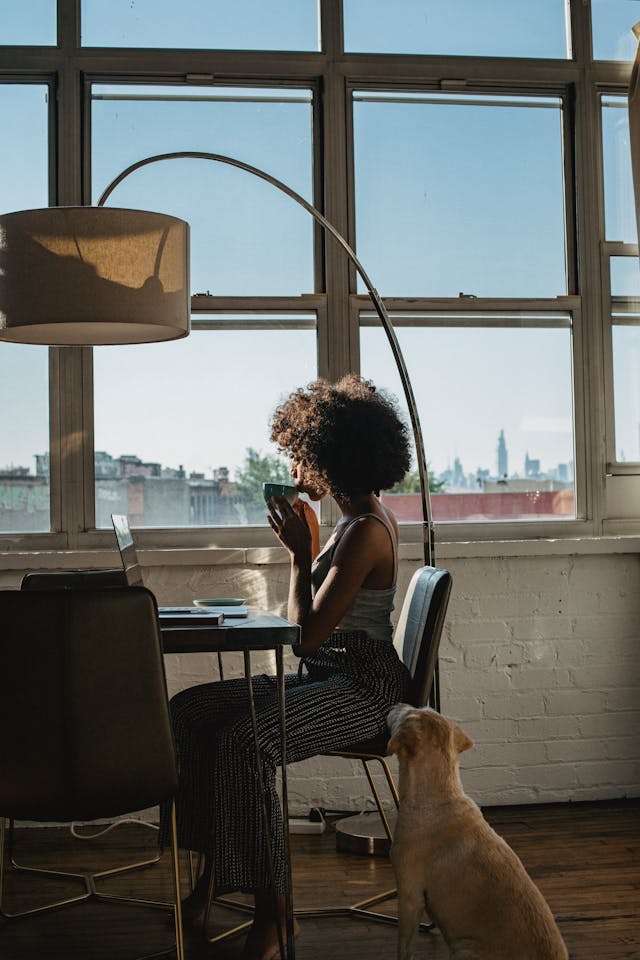 Woman working at home with a dog by her side
